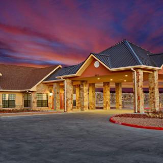 A beautifully lit building with a grand entrance at sunset.