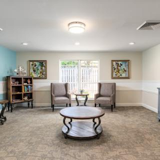 A cozy and modern waiting area featuring comfortable seating and decorative artwork.