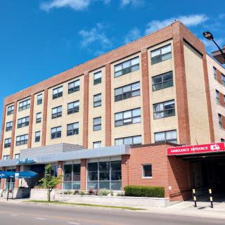 A hospital building with an emergency entrance located in an urban area.