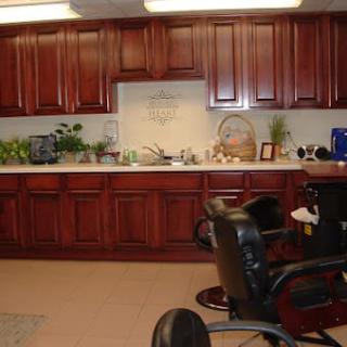 An office workspace featuring wooden cabinets and chairs, decorated with plants.