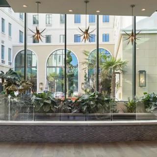 A modern lobby with large glass windows and lush indoor plants.