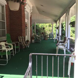 A peaceful porch inviting relaxation with comfortable seating and greenery.