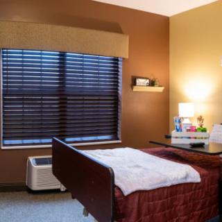 A cozy room with a hospital bed, warm lighting, and decorative elements on the nightstand.