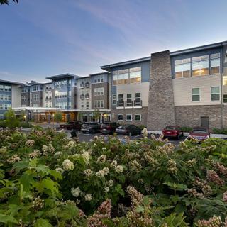Modern building surrounded by greenery in the evening light.