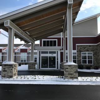 A modern building entrance featuring a covered area and snow on the ground.