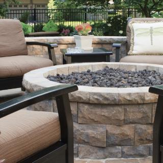 Cozy outdoor seating area with a central fire pit surrounded by comfortable patio chairs.