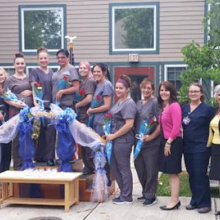 A joyful team celebrates their achievement with smiles and decorations.
