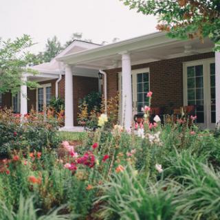 A beautiful house with a vibrant garden filled with colorful flowers.