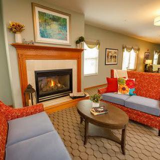 A cozy living room featuring a fireplace, colorful sofas, and elegant decor.