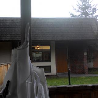A view of a house with a cloudy sky in the background.