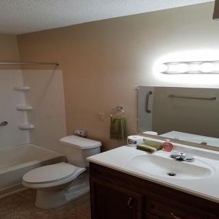 A clean, well-lit bathroom with a sink, toilet, and bathtub.