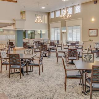 A spacious and well-lit dining area with neatly arranged tables and chairs.