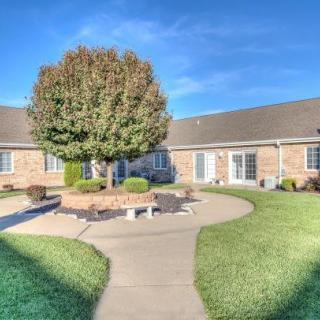 A serene courtyard with a central tree and surrounding pathway on a sunny day.