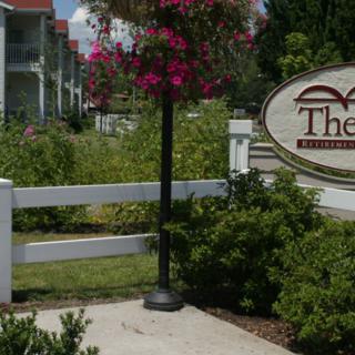 A landscaped garden area with a sign and flowering plants.