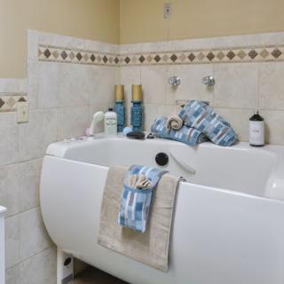 A tidy bathroom featuring a bathtub with neatly arranged towels and hygiene products.