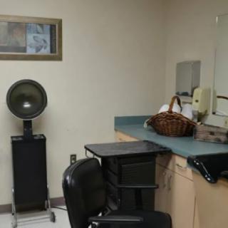 A cozy hair salon setup with a chair, mirror, and hair dryer.