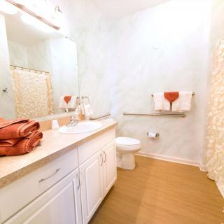 A modern bathroom with a sink, mirror, and towels.