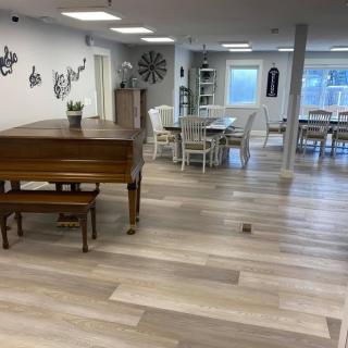 A cozy room featuring a piano and dining area with modern decor.