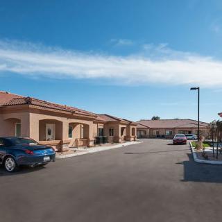 A view of residential buildings with a parking lot under a clear blue sky.