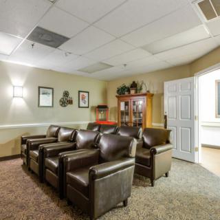 A cozy waiting room with leather chairs and warm lighting.