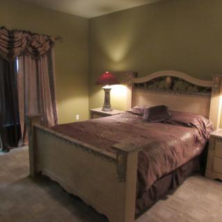 A cozy bedroom with a large wooden bed and matching nightstands.
