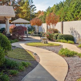 A beautifully landscaped garden with a winding pathway leading to a gazebo.