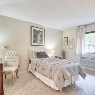 A cozy bedroom featuring a neatly made bed, elegant furniture, and soft lighting.