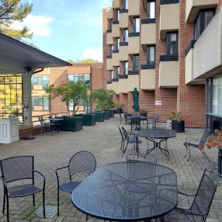 A serene outdoor patio area with tables and chairs, surrounded by a modern building.