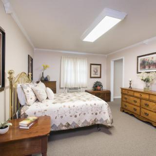 A well-furnished bedroom with a bed, dresser, and nightstand.