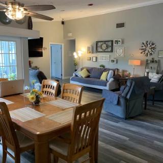 A modern and cozy living room with an adjacent dining area featuring wood flooring and stylish furniture.