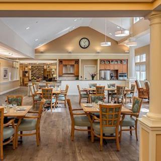 A cozy and inviting dining area with neatly arranged tables and chairs, featuring warm lighting and elegant decor.
