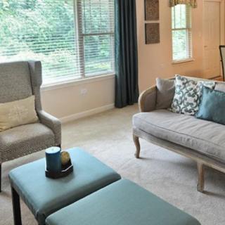 A cozy living room with elegant furniture and large windows.