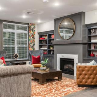 A cozy living room with a fireplace, bookshelves, and comfortable seating.