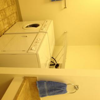 A laundry room with a washing machine and dryer, accompanied by a blue towel hanging on the wall.