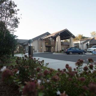 A building entrance with a parking lot in the foreground on a clear day.