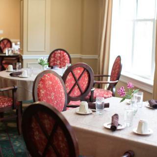 An elegant dining room setup with tables and chairs ready for guests.
