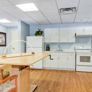 A modern kitchen interior with white cabinets and wooden flooring.