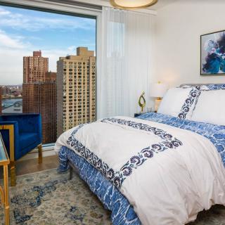 A cozy bedroom with a city view and stylish decor.