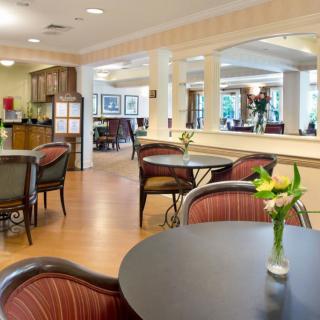 A cozy dining area with tables, chairs, and floral decorations.
