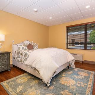 A cozy bedroom with a single bed and a decorative carpet.