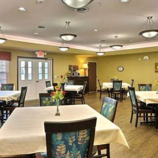 A well-lit dining room with neatly arranged tables and chairs, featuring a cozy and inviting atmosphere.