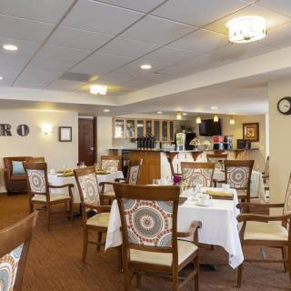A cozy and well-decorated restaurant dining room with empty tables and chairs.