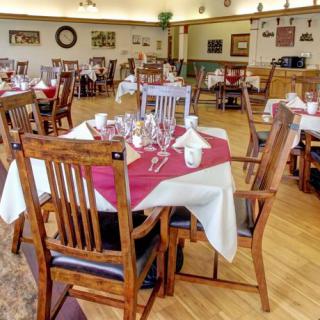 A cozy restaurant dining area with neatly set tables and wooden chairs.