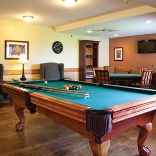 A cozy recreation room featuring a pool table and comfortable seating.