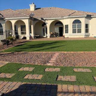 A beautiful house with a well-maintained lawn and stone pathway.
