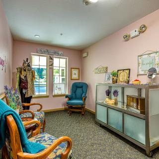 A cozy room featuring upholstered chairs, a shelving unit, and vintage decor.
