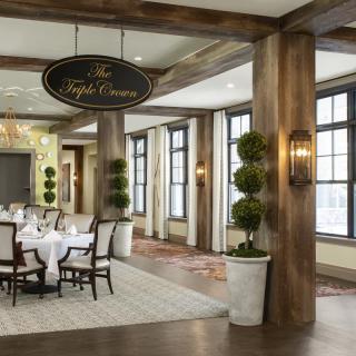 An elegant restaurant interior with large windows and a neatly arranged dining area.