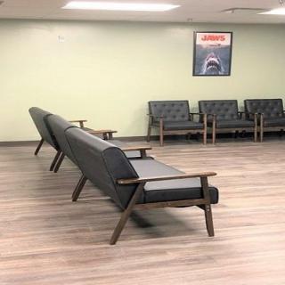 A spacious waiting room with modern seating and a poster on the wall.