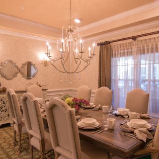 An elegant dining room featuring a beautifully set table and a stunning chandelier.