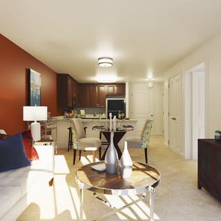 A modern apartment showcasing an open floor plan with a cozy living room, dining area, and kitchen.